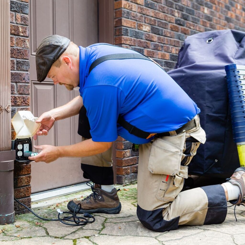 man checking electrical outlet of home exterior - Gross Inspection Services