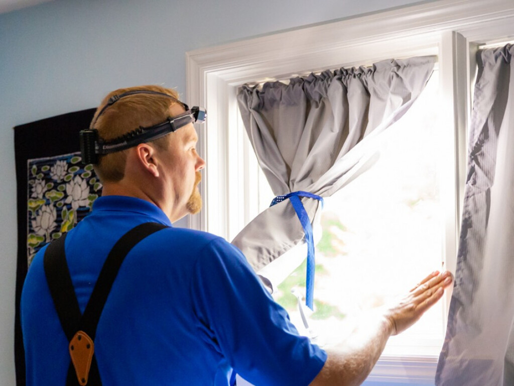 Man checking curtains of home